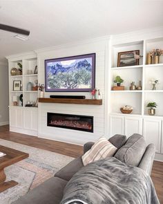 a living room filled with furniture and a flat screen tv mounted on the wall above a fireplace