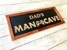 a sign that says dad's mancave with a video game controller on it