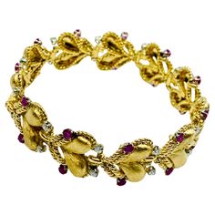 DESIGNER: Mario Buccellati CIRCA: 1960’s MATERIALS: 18K Yellow Gold GEMSTONE: Diamond, Ruby WEIGHT: 49.9 grams MEASUREMENTS: 7" x 3/4" HALLMARKS: M. Buccellati, Milano ITEM DETAILS: An extraordinary Mario Buccellati bracelet made of 18k gold, features ruby and diamond.  The bracelet comprises eleven heart-shaped links which are framed by braided gold wires. Each link is accented with two rubies and two diamonds. The hearts are made of textured gold and bear signature Buccellati engraving technique. The braided frames create a lightweight, airy look. This bracelet is full of sophisticated grace and represents maker’s exceptional quality and recognizable style. Buccellati Bracelet, Design Bracelet, Gold Armband, Gold Wire, Gold Texture, Gold Heart, Heart Of Gold, Heart Design, Bracelet Designs