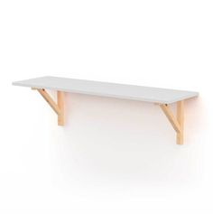 a white table with two wooden legs on the top and one leg up against the wall