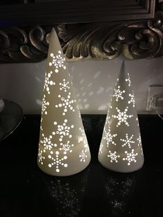 two white christmas trees sitting on top of a table