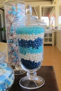 there are many different types of candies in glass containers on the table and one is filled with candy