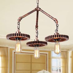 three light chandelier hanging over a bed in a room with beige walls and curtains