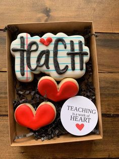 some cookies in a box that say teach and have hearts on them with the words teaching is work of heart