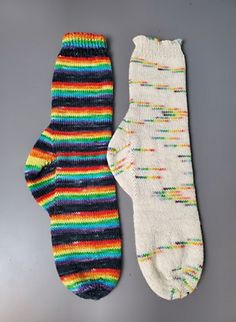 two pairs of multicolored socks laying next to each other