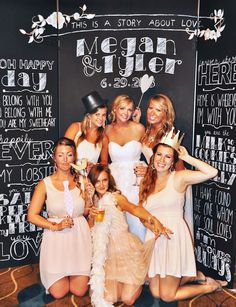 a group of women standing next to each other in front of a chalkboard wall