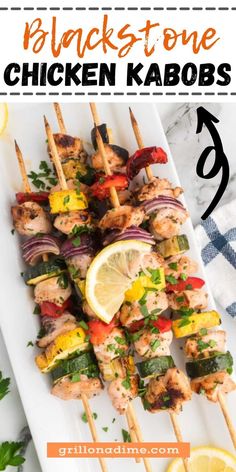 chicken kabobs on skewers with lemon wedges and cilantro