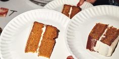 two pieces of cake on paper plates being held by someone's hands at a table