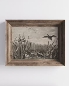 a painting hanging on the wall next to a wooden frame with birds flying above it