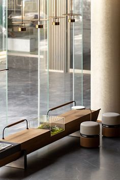 a bench sitting in front of a glass wall