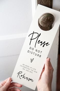 a person is holding up a sign that says please don't disturb with a button on it