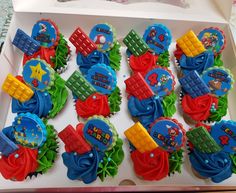 cupcakes in the shape of trains and cars are arranged on a white box