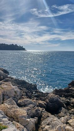 the sun shines brightly on the water and rocks