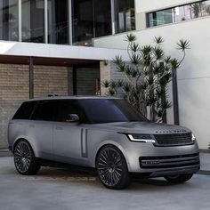 the new range rover is parked in front of a large building with glass doors and windows