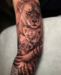 a man's arm with a lion and cubs tattoo on it