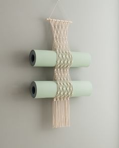 three rolls of paper hanging on a wall next to each other with some string attached to them