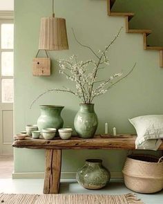 a wooden table topped with vases next to a stair case filled with flowers and candles