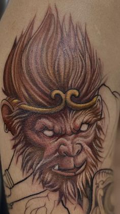 a tattoo with a monkey on it's thigh and an arrow in its mouth