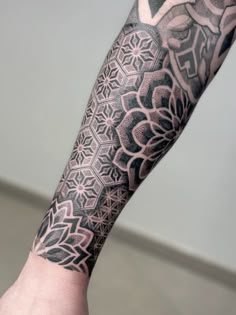 a man's arm with an intricate tattoo design on the left side of his arm