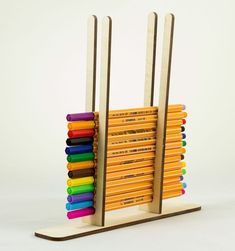 a stack of colored pencils sitting on top of a wooden stand