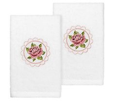 two white towels with pink roses on them