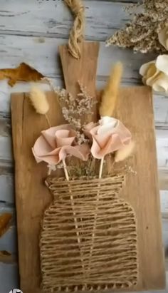 some flowers are in a vase made out of wood and wicker on the table