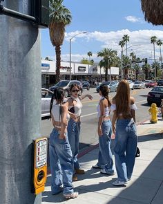 four women are standing on the side walk