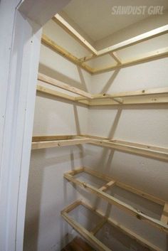 an empty closet with wooden shelves in it