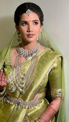 a woman in a green sari and matching jewelry