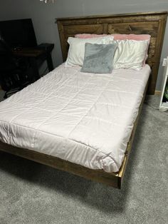 a bed sitting in a bedroom next to a dresser and tv on top of a carpeted floor