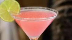 a pink drink with a lime slice on the rim