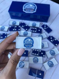 a person holding up a domino board with blue and white tiles in the back ground