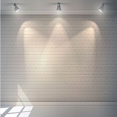 three spotlights are shining on a white brick wall