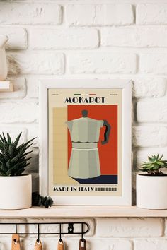 an art print on a shelf in front of a brick wall with potted plants