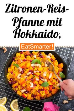 a pan filled with rice and vegetables on top of a table next to sliced lemons