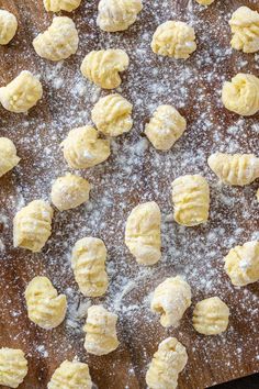 doughnuts on a wooden cutting board covered in powdered sugar