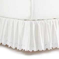 a white bed skirt with scalloped edges