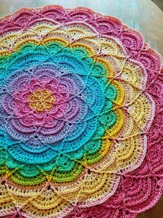 a multicolored crocheted doily sits on a table