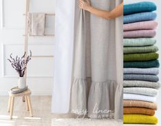 a woman standing next to a stack of towels