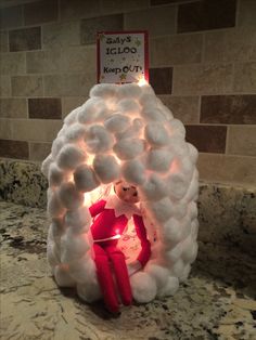 a light up snow man sitting in the middle of a kitchen counter next to a tile wall