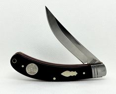 a knife that is sitting on top of a black case with a silver emblem and two knives sticking out of it's sides