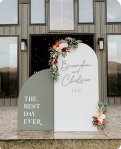 a sign that says the best day ever with flowers on it in front of a building