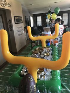 an inflatable table with footballs, drinks and balloons on it at a party