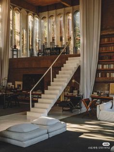 a living room filled with lots of furniture and bookshelves