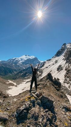 a person standing on top of a mountain with their arms in the air