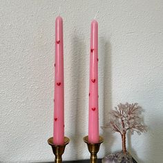 two pink candles sitting on top of a table