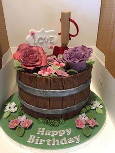 a birthday cake made to look like a barrel with flowers in it and a sign that says love