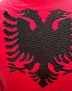 the back of a red shirt with a black eagle on it's left chest