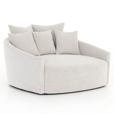 a white round chair with pillows on the seat and back cushions in front of it