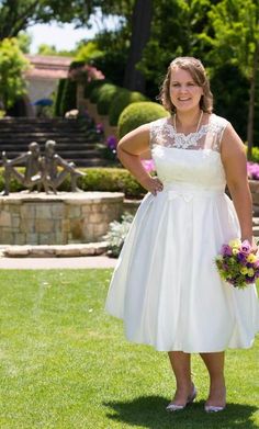 a woman in a white dress is standing on the grass